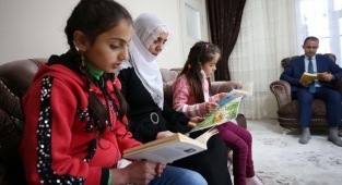 Gönüllü öğretmenler evleri ziyaret edip öğrenci ve velilerle kitap okuyor